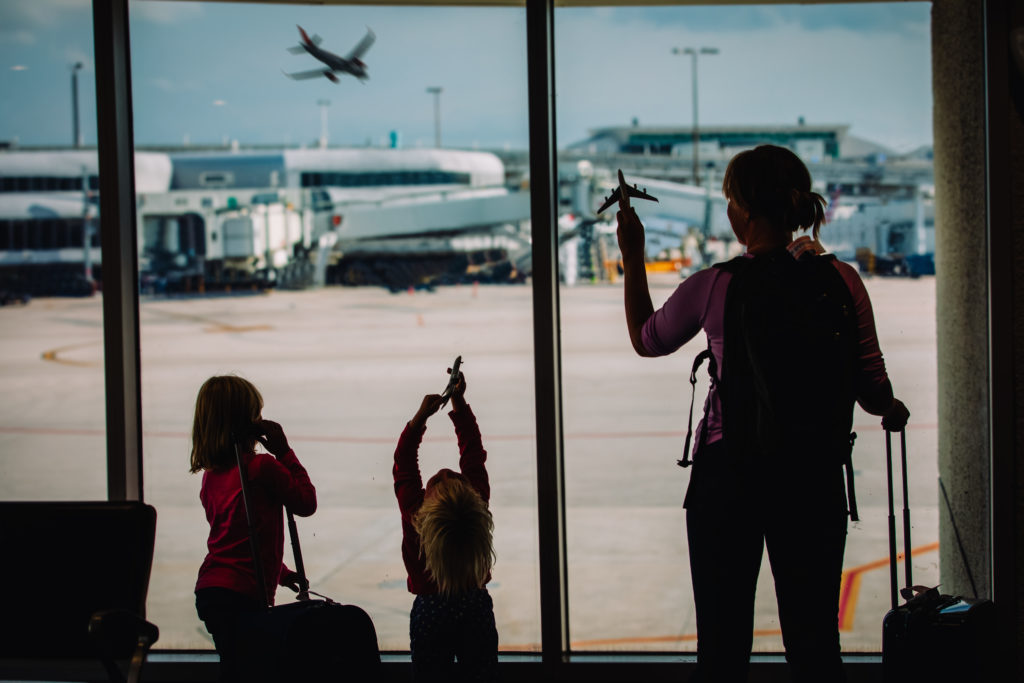 Mother and two children watching planes on the runway