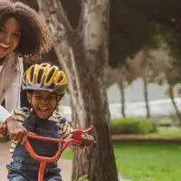 Mom teaching child how to ride a bike
